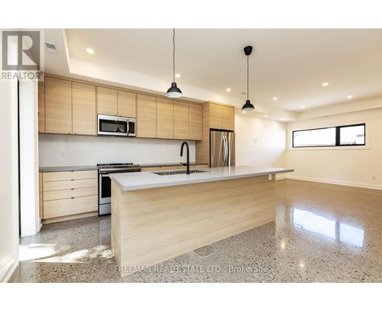 A modern kitchen with wooden cabinets and a granite countertop.