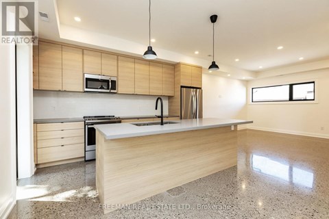 A modern kitchen with wooden cabinets and a granite countertop.