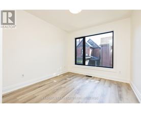 A room with a window showing a view of a building outside.