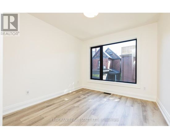 A room with a window showing a view of a building outside.