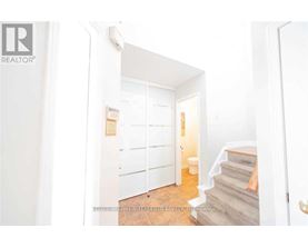 A hallway with a staircase leading to the second floor.