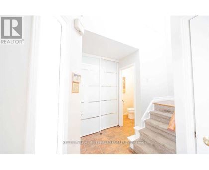 A hallway with a staircase leading to the second floor.