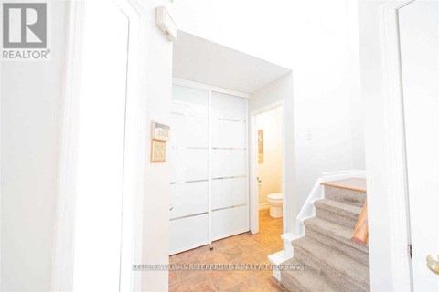 A hallway with a staircase leading to the second floor.