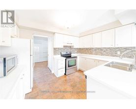 A kitchen with white cabinets and a tile backsplash.