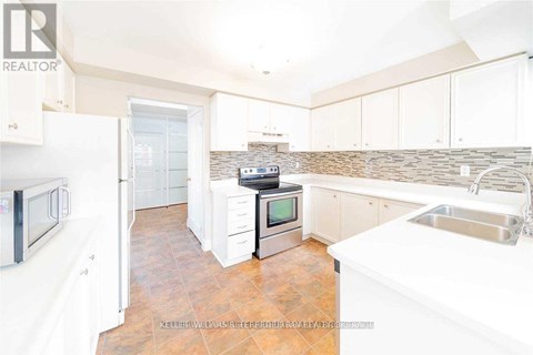A kitchen with white cabinets and a tile backsplash.