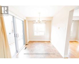A spacious room with a tiled floor and a chandelier hanging from the ceiling.