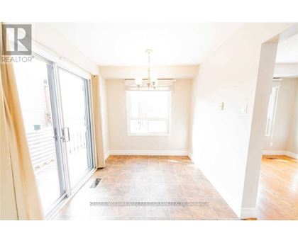 A spacious room with a tiled floor and a chandelier hanging from the ceiling.