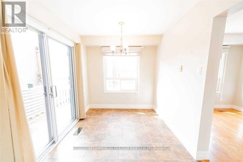A spacious room with a tiled floor and a chandelier hanging from the ceiling.