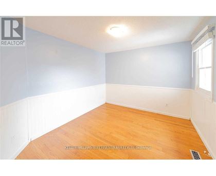 A room with wooden flooring and a window.