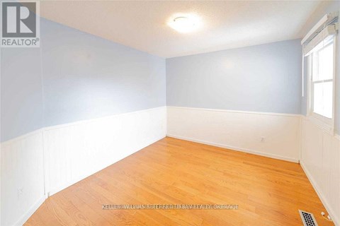 A room with wooden flooring and a window.