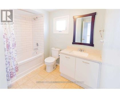 A small bathroom with a toilet, sink, and shower.