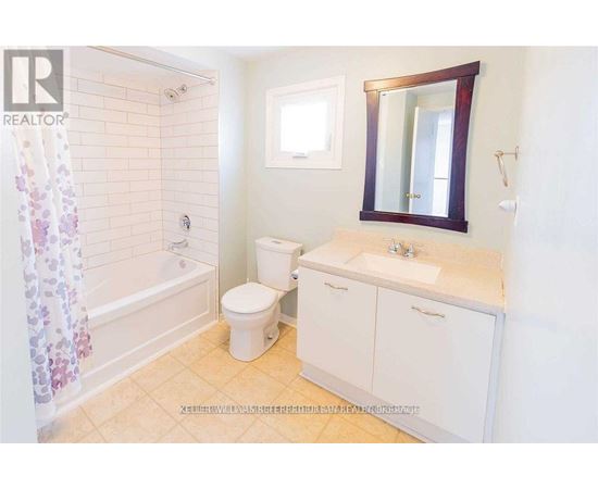 A small bathroom with a toilet, sink, and shower.