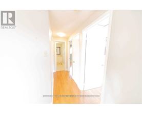 A hallway with a wooden floor and white walls.