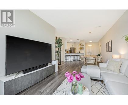 A modern living room with a large television and a coffee table with flowers on it.