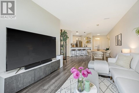 A modern living room with a large television and a coffee table with flowers on it.