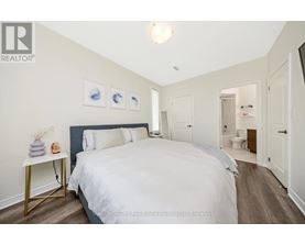 A bedroom with a large bed and a nightstand with a lamp.