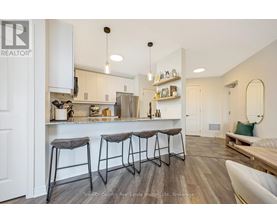 A modern kitchen with white cabinets and a wooden floor.