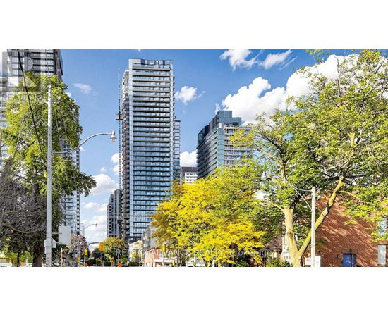 A cityscape with trees and buildings under a blue sky.