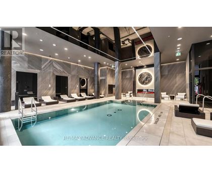 A large indoor swimming pool with lounge chairs and a tiled floor.