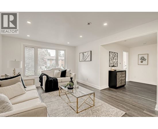 A living room with a white couch and a glass coffee table.
