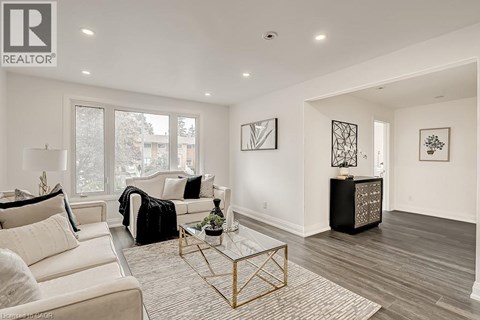A living room with a white couch and a glass coffee table.