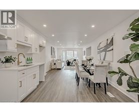 A modern kitchen with white cabinets and a dining table set for two.