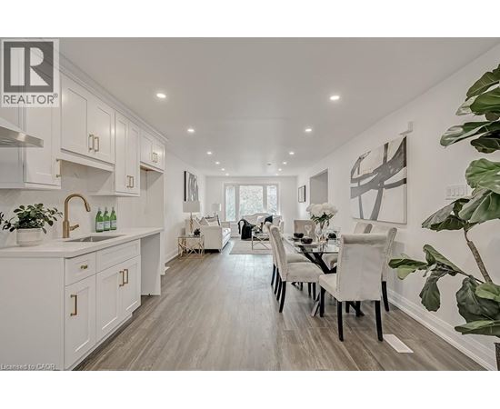 A modern kitchen with white cabinets and a dining table set for two.