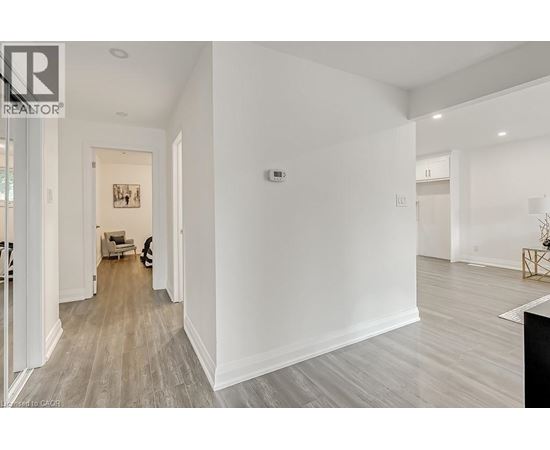A spacious room with a wooden floor and white walls.