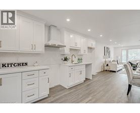 A white kitchen with a sign that says "Kitchen" on the counter.