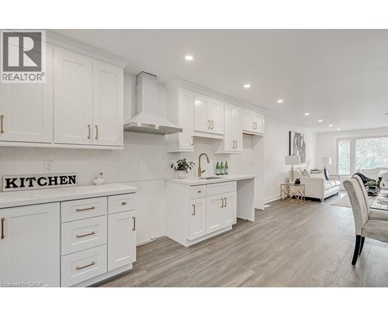 A white kitchen with a sign that says "Kitchen" on the counter.