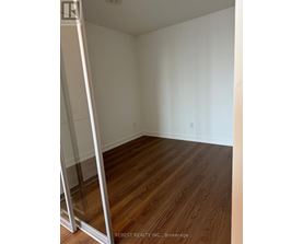 A room with wooden flooring and white walls.