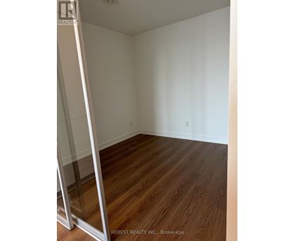 A room with wooden flooring and white walls.