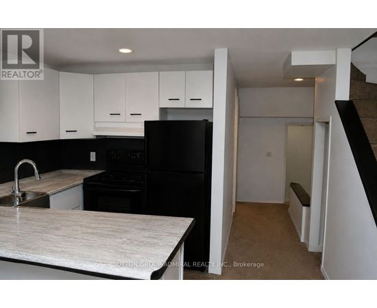A kitchen with black appliances and white cabinets.