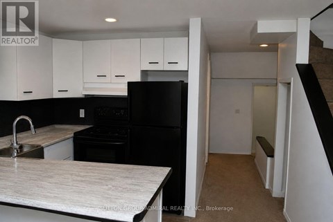 A kitchen with black appliances and white cabinets.