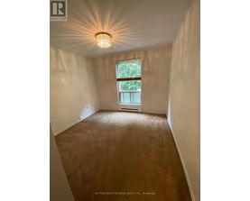 A room with a window and a light fixture on the ceiling.