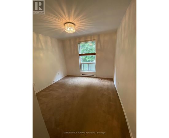 A room with a window and a light fixture on the ceiling.