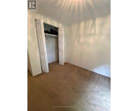 A room with a brown carpet and white walls with a doorway open.