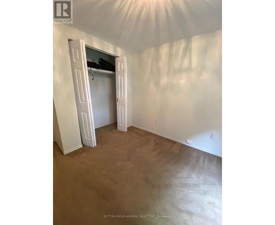 A room with a brown carpet and white walls with a doorway open.