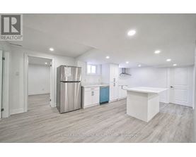 A kitchen area with a white countertop and a stainless steel refrigerator.