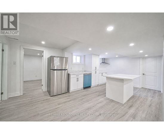 A kitchen area with a white countertop and a stainless steel refrigerator.