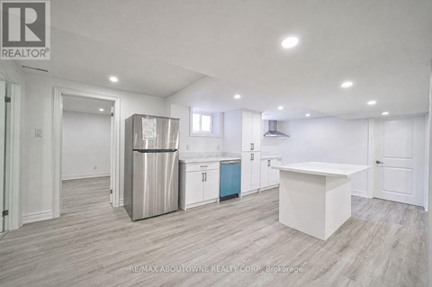 A kitchen area with a white countertop and a stainless steel refrigerator.