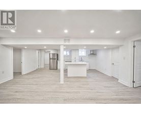 A spacious, empty room with a white kitchen island in the middle.