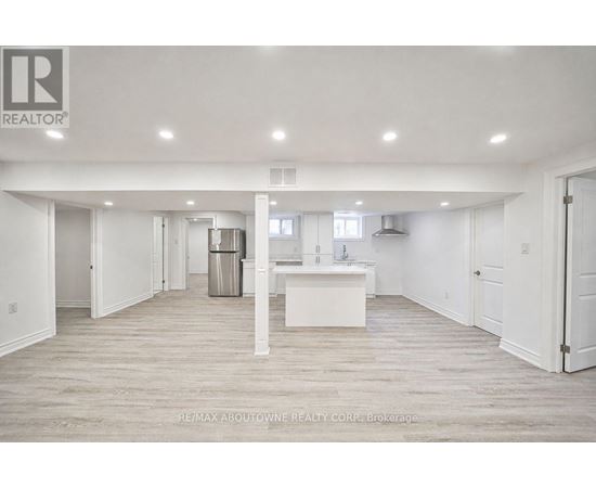 A spacious, empty room with a white kitchen island in the middle.