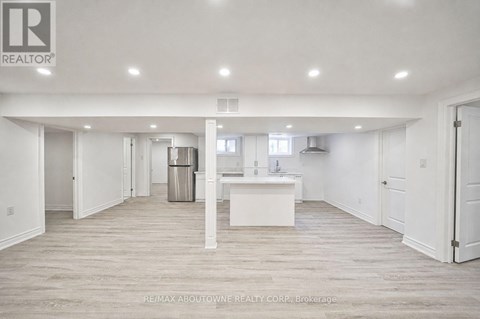 A spacious, empty room with a white kitchen island in the middle.