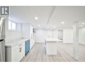 A white kitchen with a refrigerator, cabinets, and a countertop.