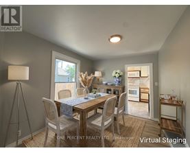 A dining room with a table set for two and a view of the backyard.