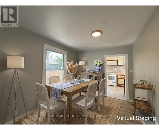 A dining room with a table set for two and a view of the backyard.