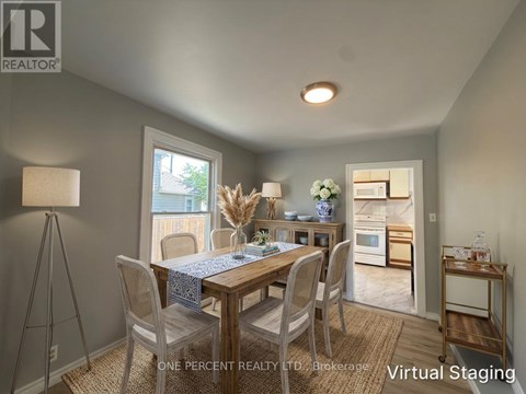 A dining room with a table set for two and a view of the backyard.
