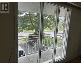A view from inside a room looking out through a sliding glass door.