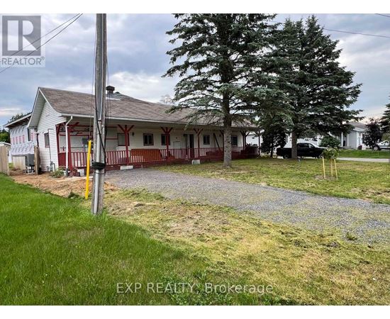 A house with a gravel driveway in front of it.